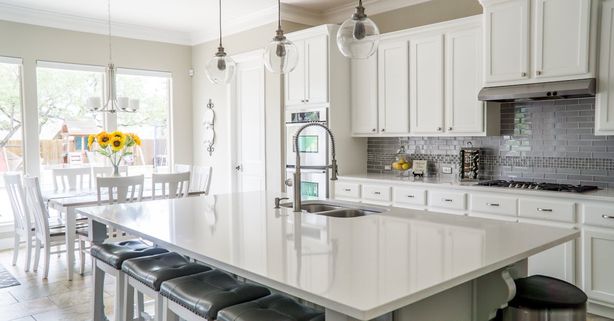 Spacious modern kitchen with white cabinets and island in natural light.